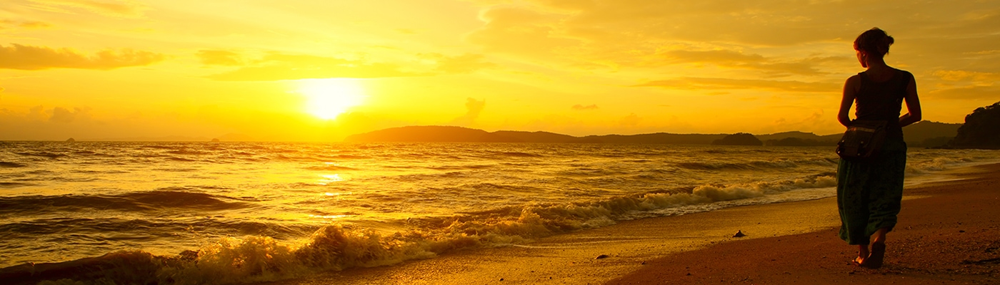 woman walking beach sunset CKR 1400x400 1